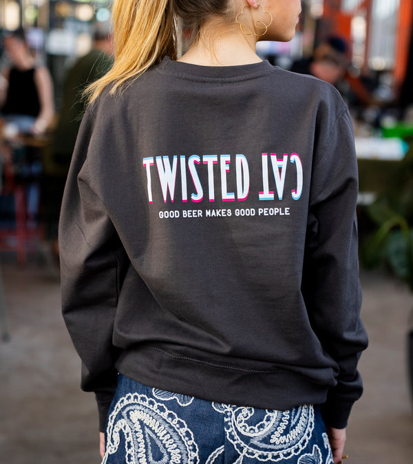 Person wearing a black sweatshirt with 'Twisted Cat' text, standing in an outdoor setting.