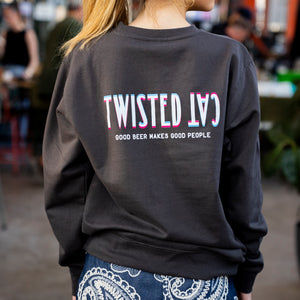 Person wearing a black sweatshirt with 'Twisted Cat' text, standing in an outdoor setting.